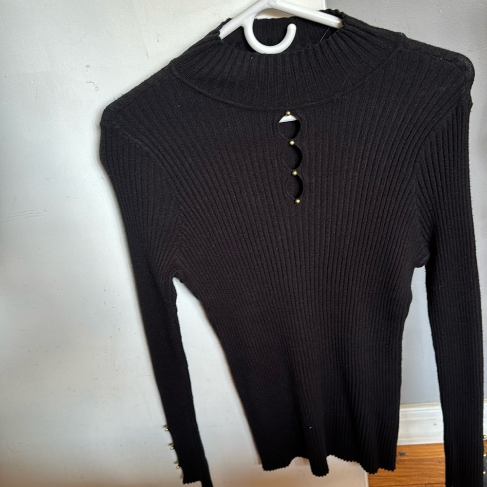 Black long sleeve shirt. It has little peep holes with gold pearls